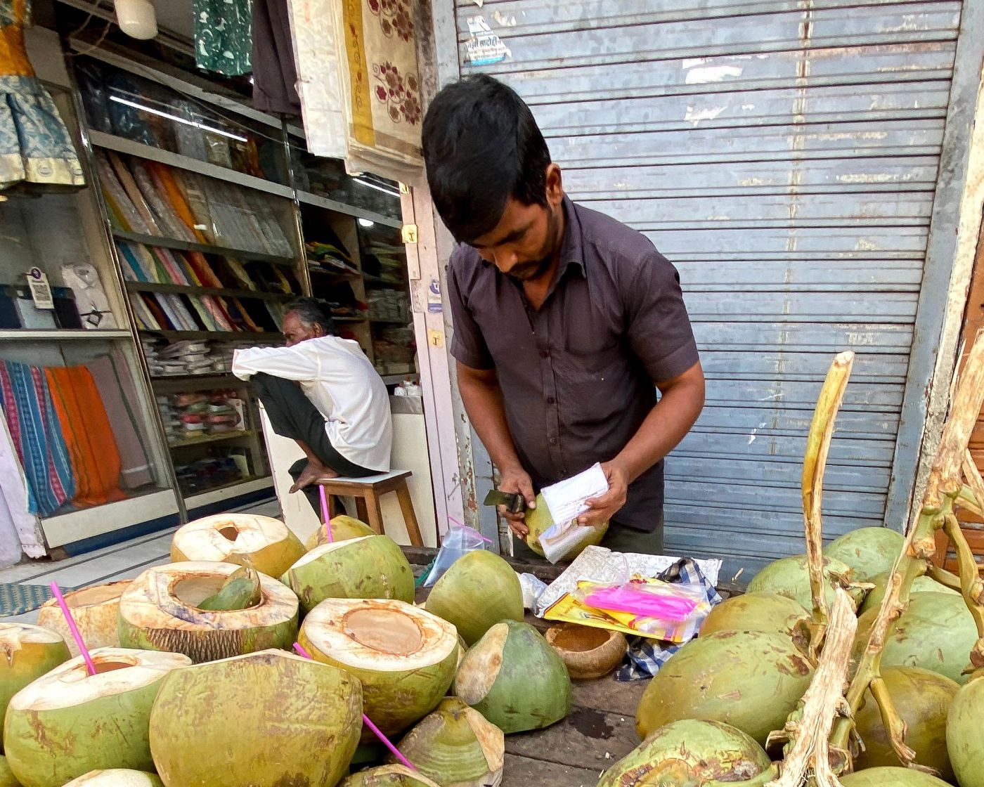 Kausar packing fresh coconut water in a small plastic bag for takeaway