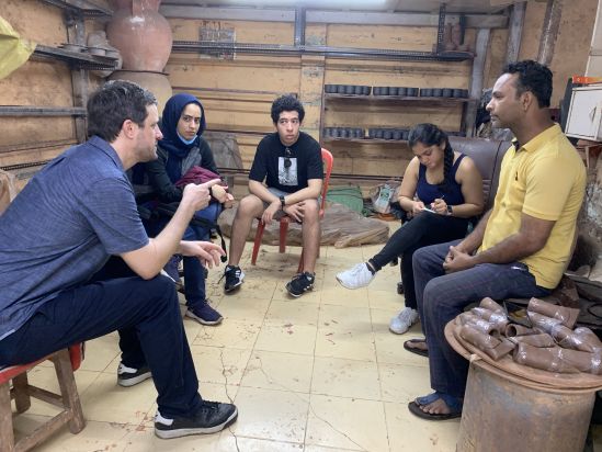 Students interacting with Abbas Glawani in his pottery workshop