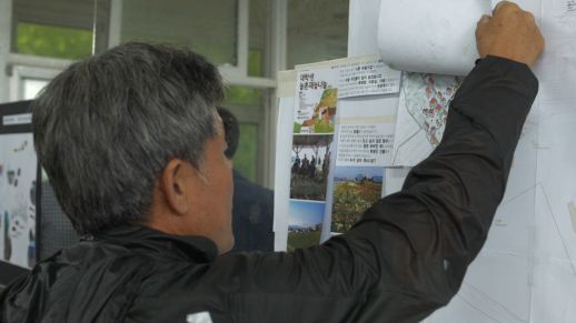 Visitors examine the proposals that are exhibited. 