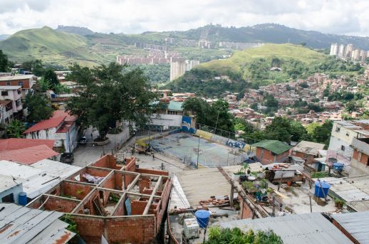 Overlooking the topography in Caracas with buildings under construction and a basketball court built by the community