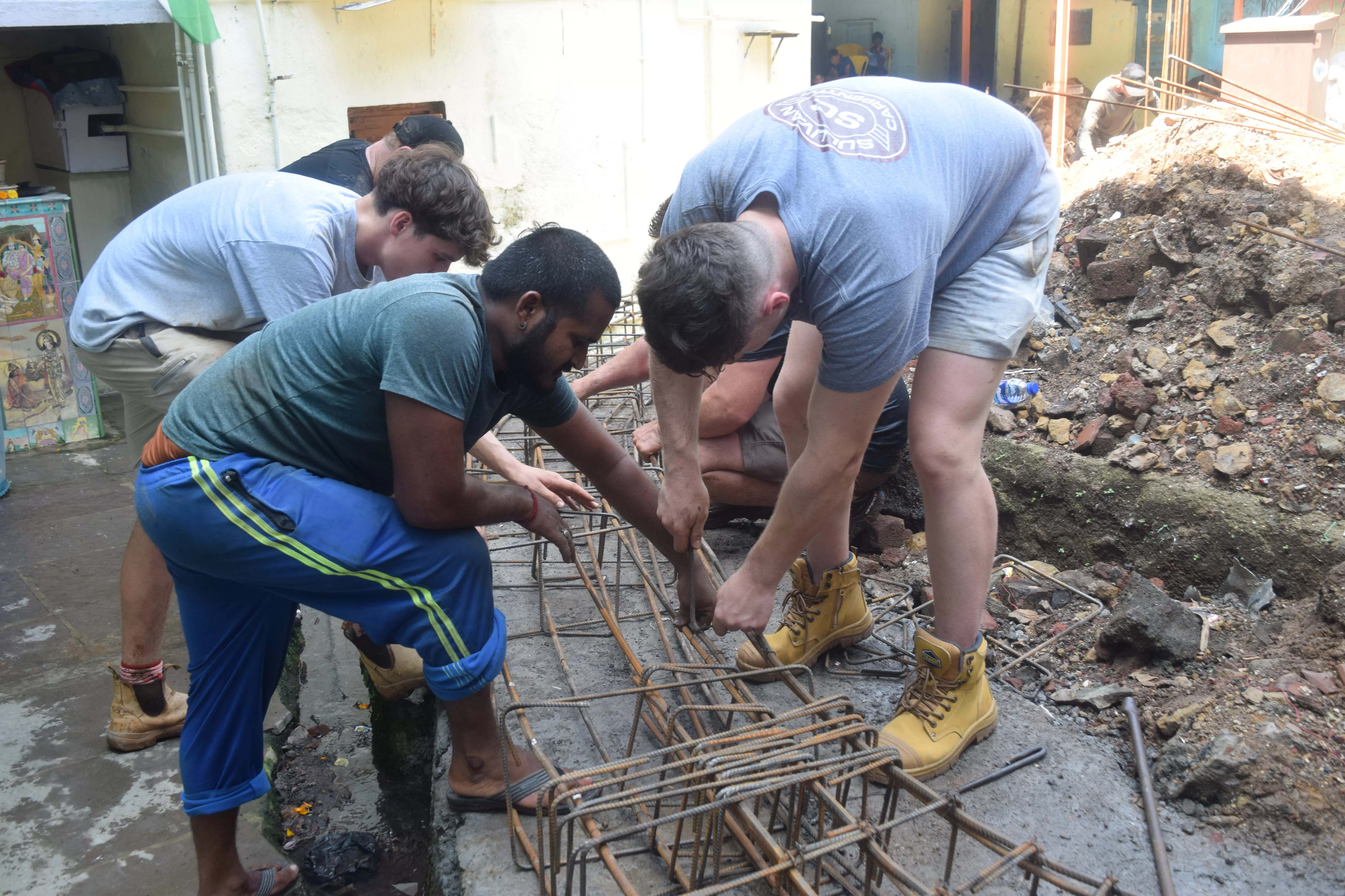 Australian and Indian building experts working on the plinth beam
