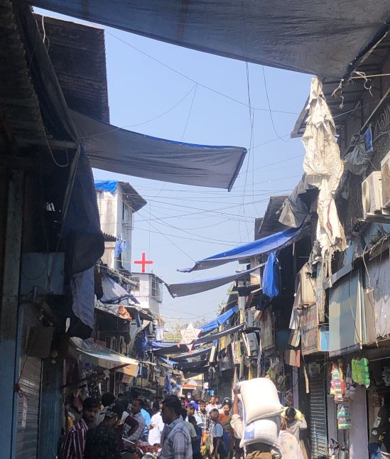 A busy market street lined with tool houses on either side