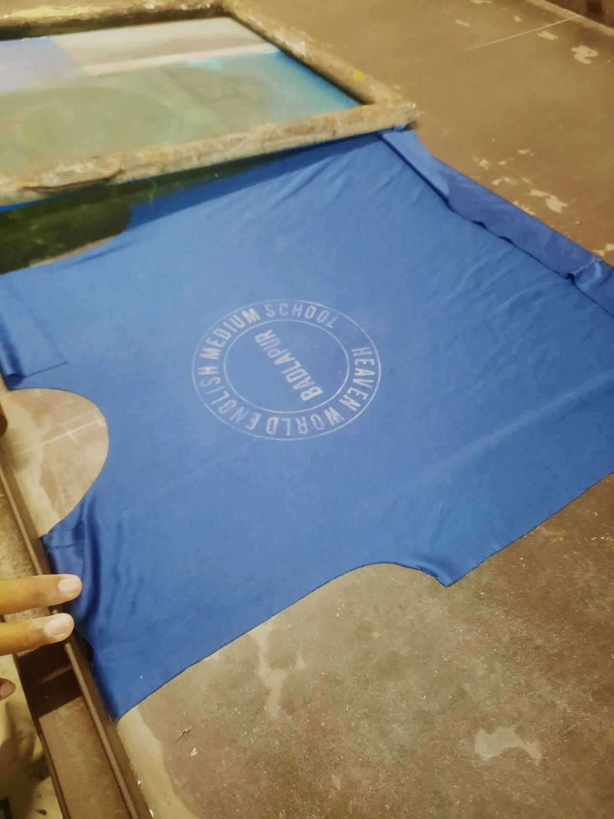 Samsuddin demonstrating the process of printing a t-shirt.