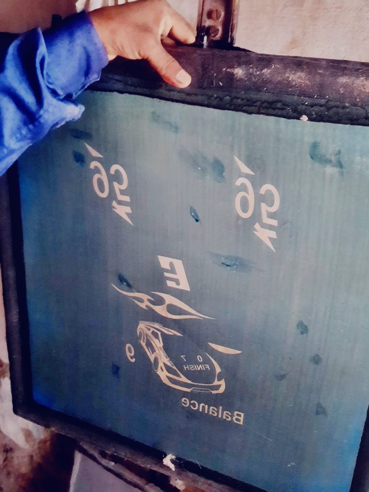 Ravi displaying the screen-printing frame he crafted.