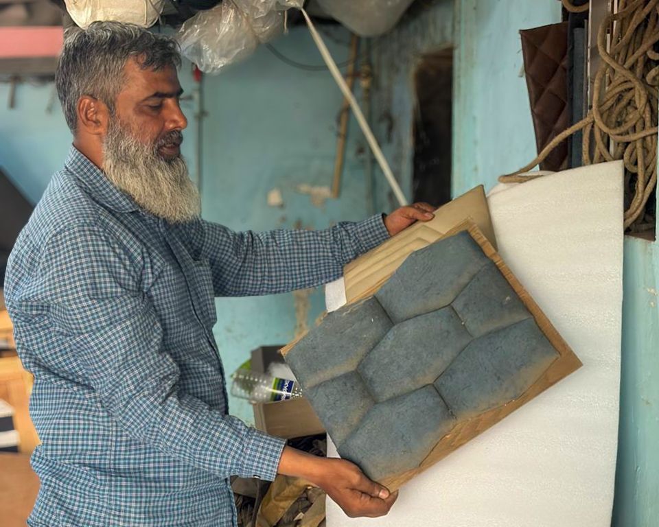Abdul showing the different kinds of work he does as a sofa maker.
