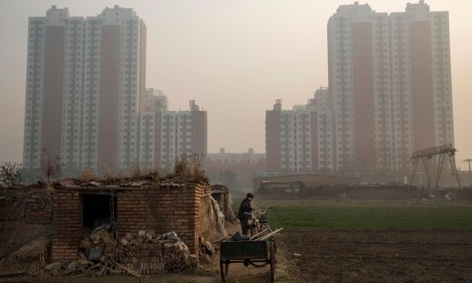  A Chinese farmer on her land, which sits next to a new housing development just outside of Beijing. Photograph: Kevin Frayer/Getty Images