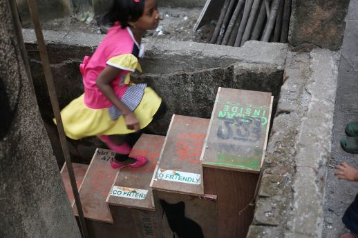 A girl climbs up a staircase built from plywood during the Khotachiwadi Imaginaries Workshop in January, 2016