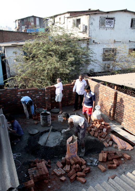 Masons laying bricks for a new space in Dharavi 