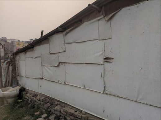 Houses in sukumbasi bastis are often constructed out of recycled materials. The exterior walls have canvas sheet coverings to prevent damage to moisture.