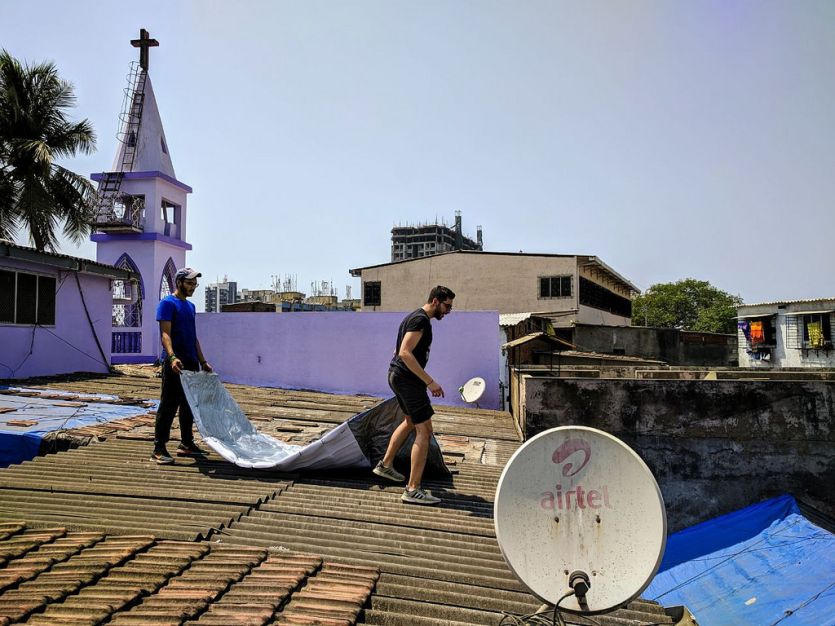 NYUAD students putting a "cool roof" cover on a house Dharavi